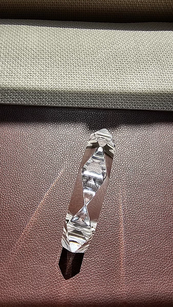 Top view of Khanak Prism acrylic bangle with diamond-shaped prism cuts on a surface.